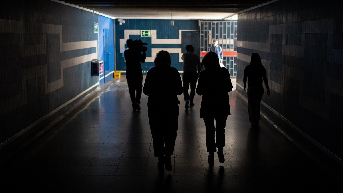 Varias personas caminan por un paso subterr&aacute;neo del Metro de Madrid tras el apag&oacute;n el&eacute;ctrico.