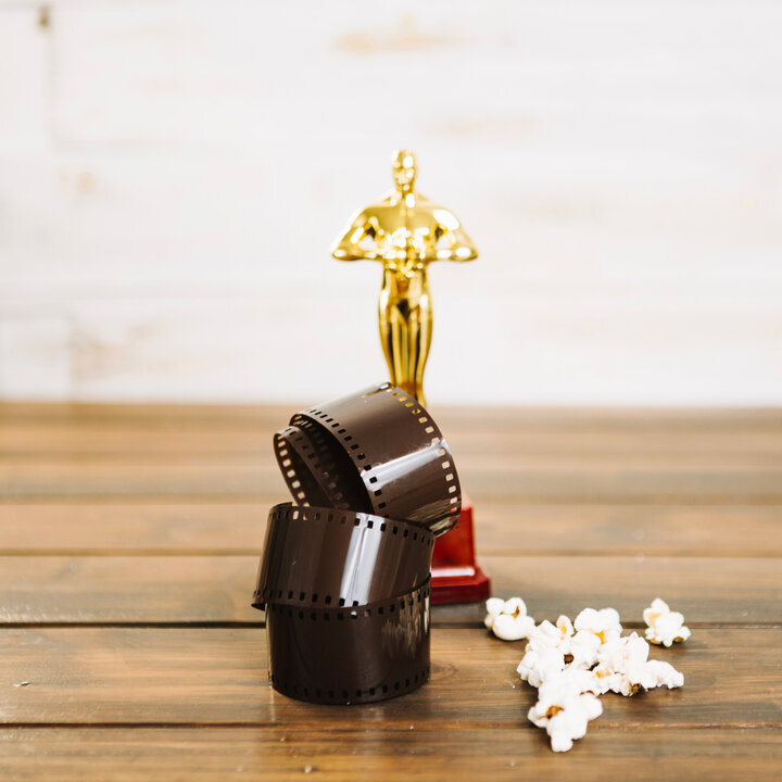 pelicula-enrollada-palomitas-de-maiz-y-estatuilla-de-oscar