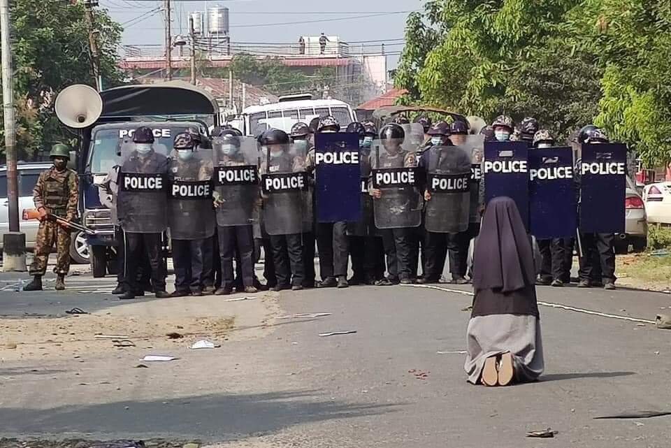 Una monja de Birmania, rezando frente a la policía. 