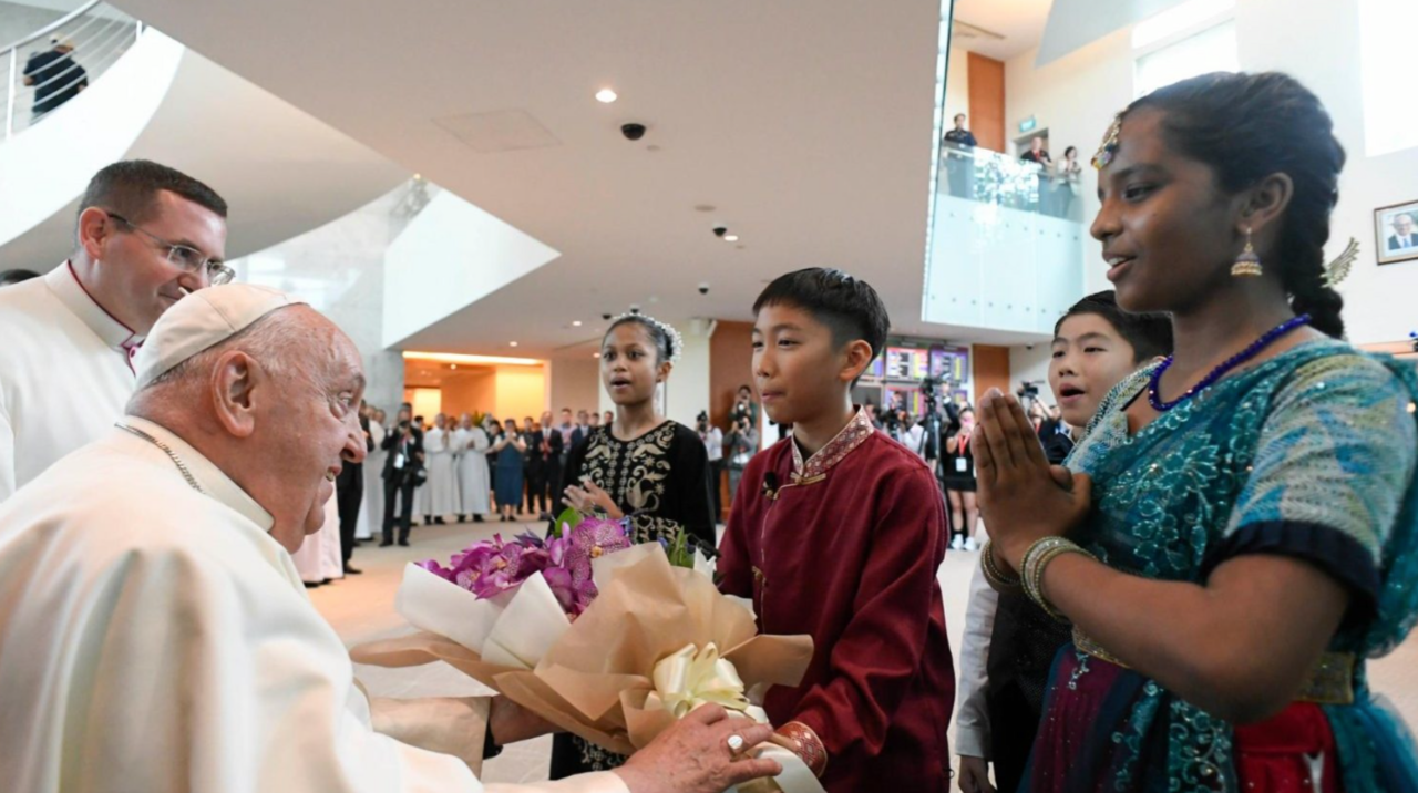 Cuatro ni&ntilde;os vestidos con trajes tradicionales dan la bienvenida al Papa a Singapur.