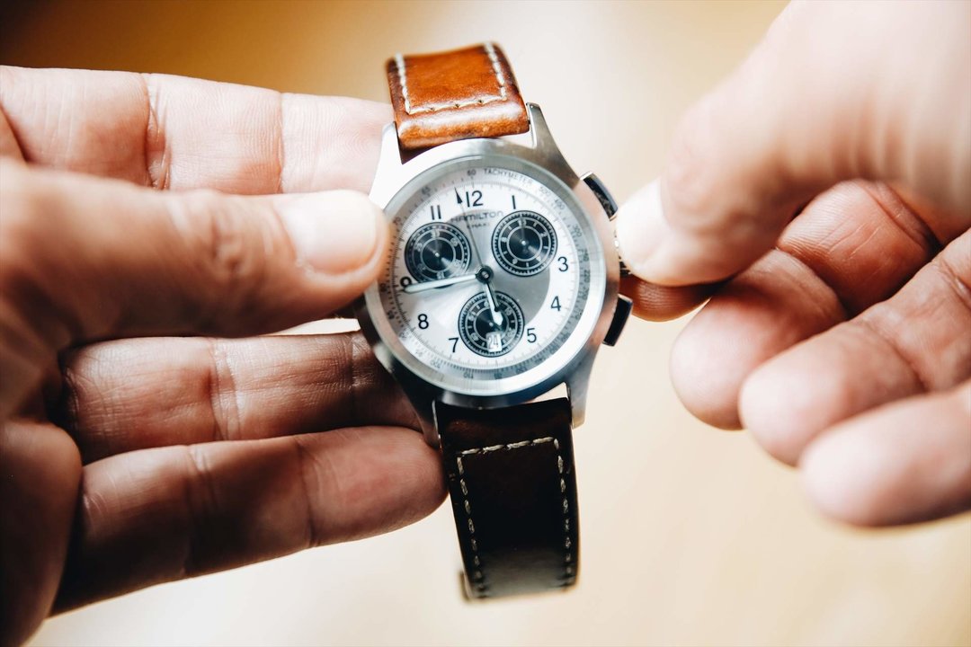 Una persona cambia la hora con las manecillas de reloj