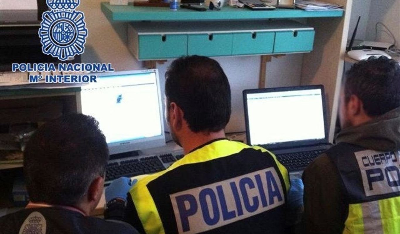 Agentes de la Policía Nacional frente a dos ordenadores.