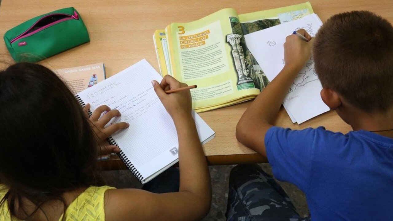 Dos ni&ntilde;os haciendo deberes.