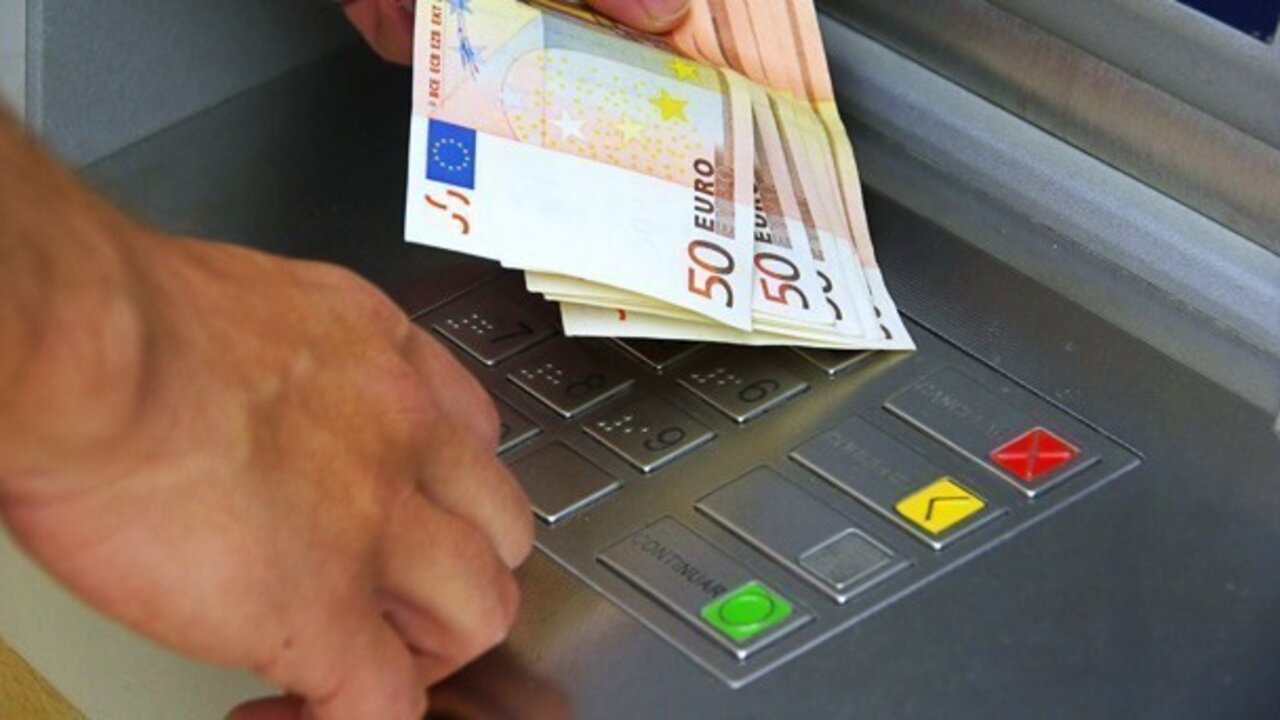 Un cliente retira dinero de un cajero.