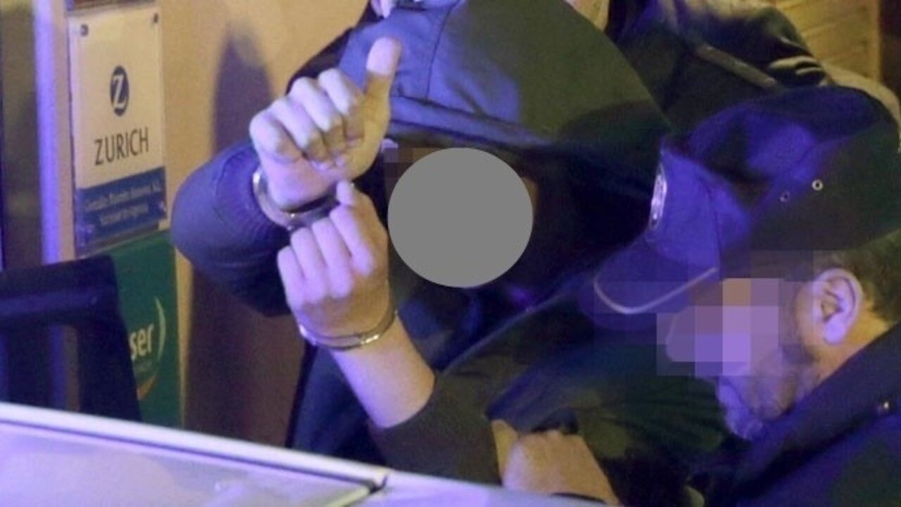 El menor detenido saluda al entrar en un veh&iacute;culo policial.