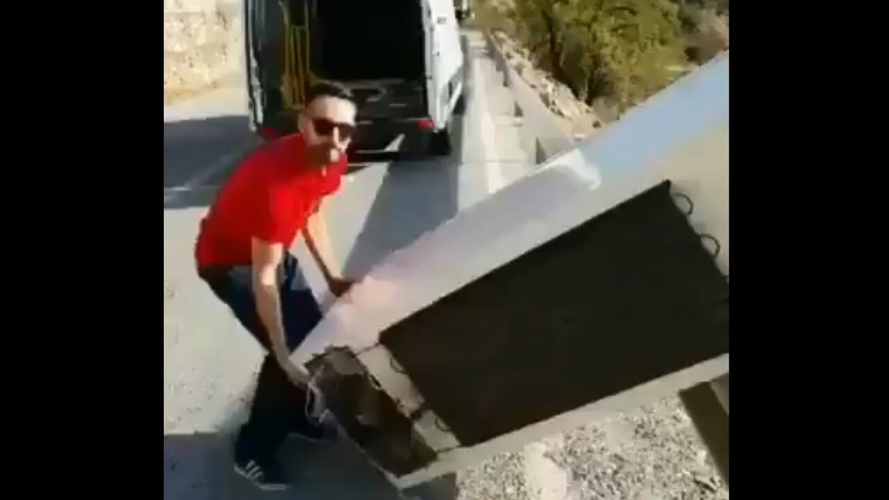 Hombre lanzando una nevera por el monte.