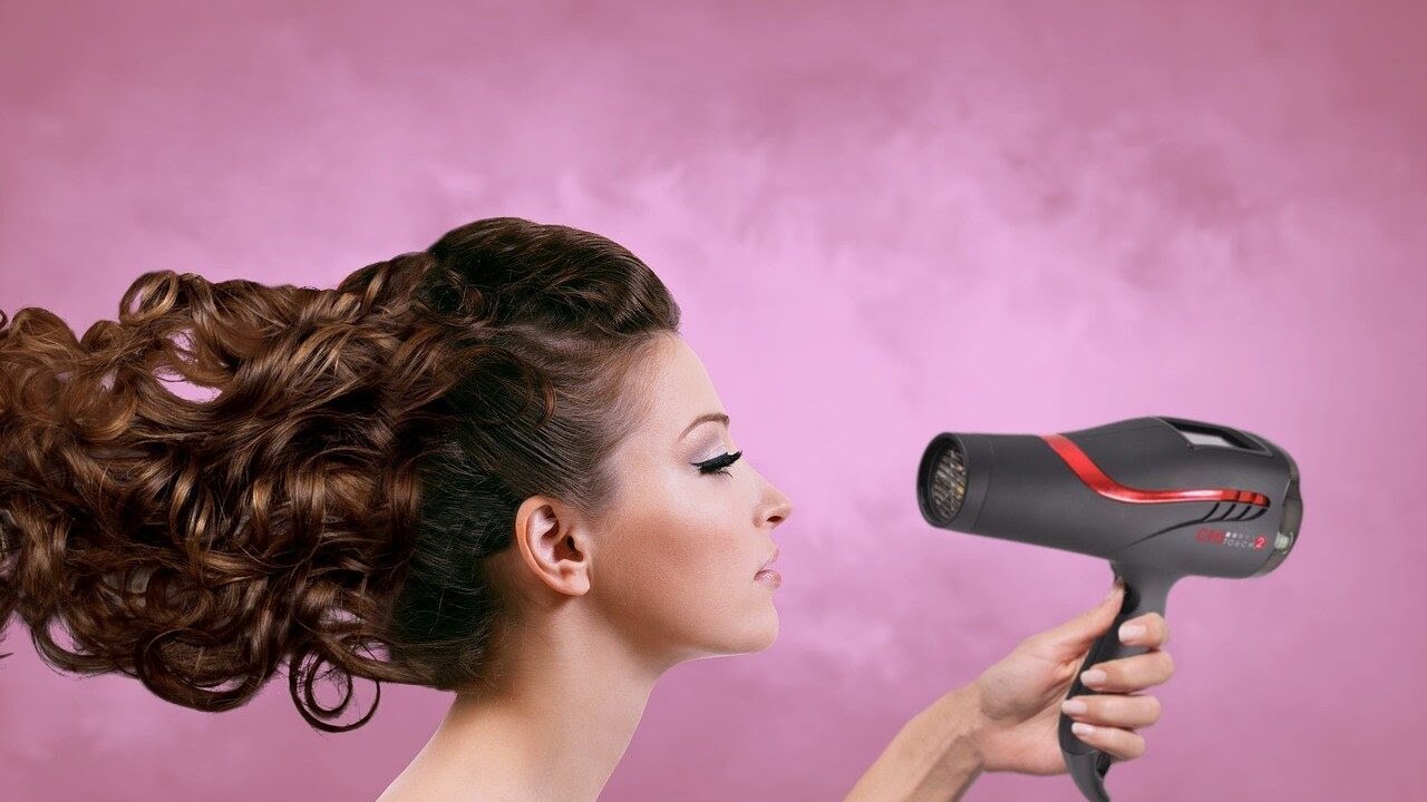 Una mujer con un secador de pelo.