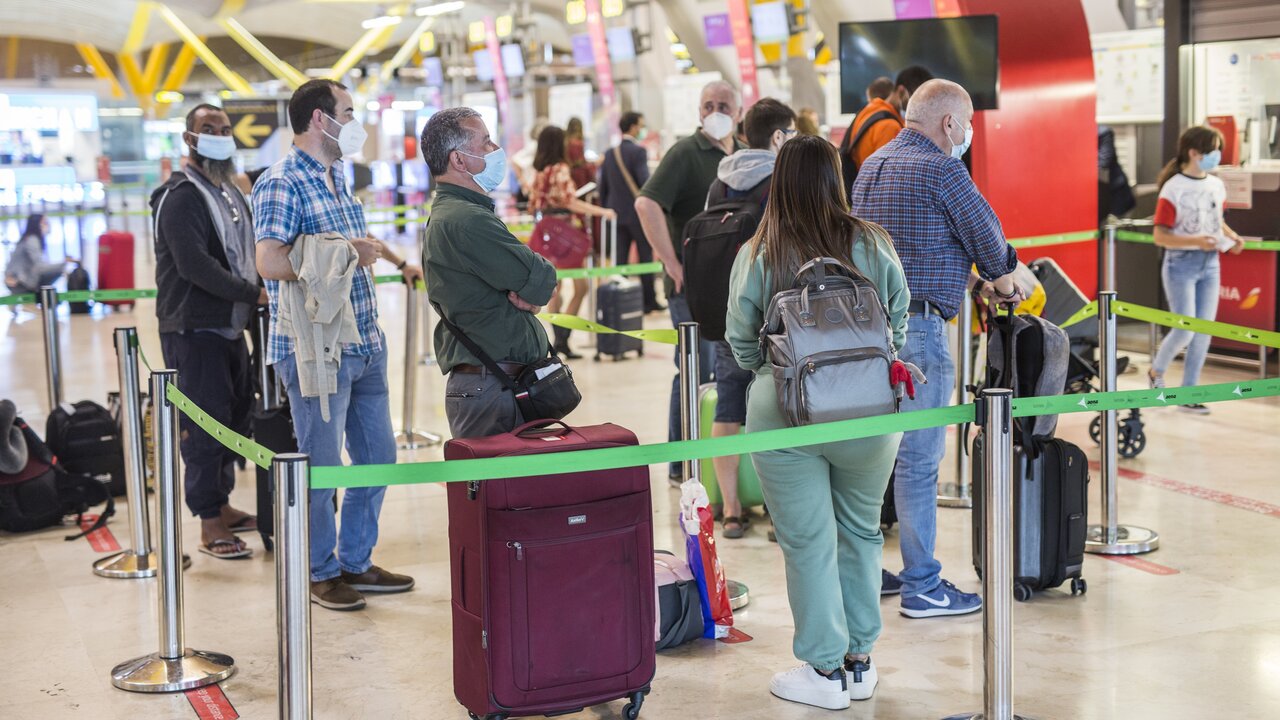 Varias personas hacen fila con maletas en la terminal T4 del Aeropuerto Adolfo Su&aacute;rez Madrid-Barajas.
