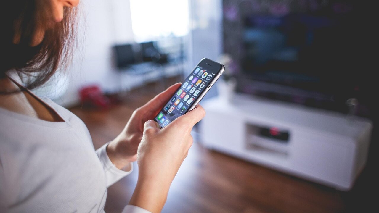 Una persona con un tel&eacute;fono m&oacute;vil.