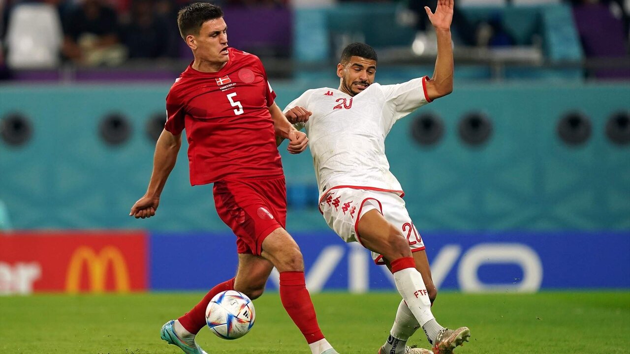 22 November 2022, Qatar, Al Rayyan: Denmark's Joakim Maehle (L) and Tunisia's Mohamed Drager battle for the ball during the FIFA World Cup Qatar 2022 Group D soccer match between Denmark and Tunisia at the Education City Stadium. Photo: Mike Egerton/PA Wire/dpa