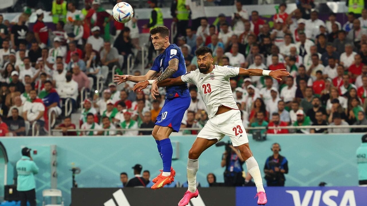 29 November 2022, Qatar, Doha: USA's Christian Pulisic (L) and Iran's Ramin Rezaeian battle for the ball during the FIFA World Cup Qatar 2022 Group B soccer match between Iran and USA at Al-Thumama Stadium. Photo: Christian Charisius/dpa
