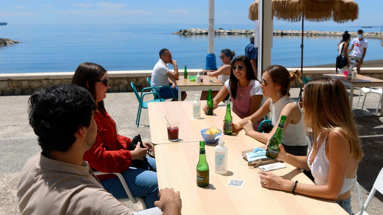 MLG 20-05-2020.-Varias personas disfrutan de la terraza de un bar en el paseo mar&iacute;timo de Pedregalejo durante la Fase 1 en M&aacute;laga.-&Aacute;LEX ZEA.