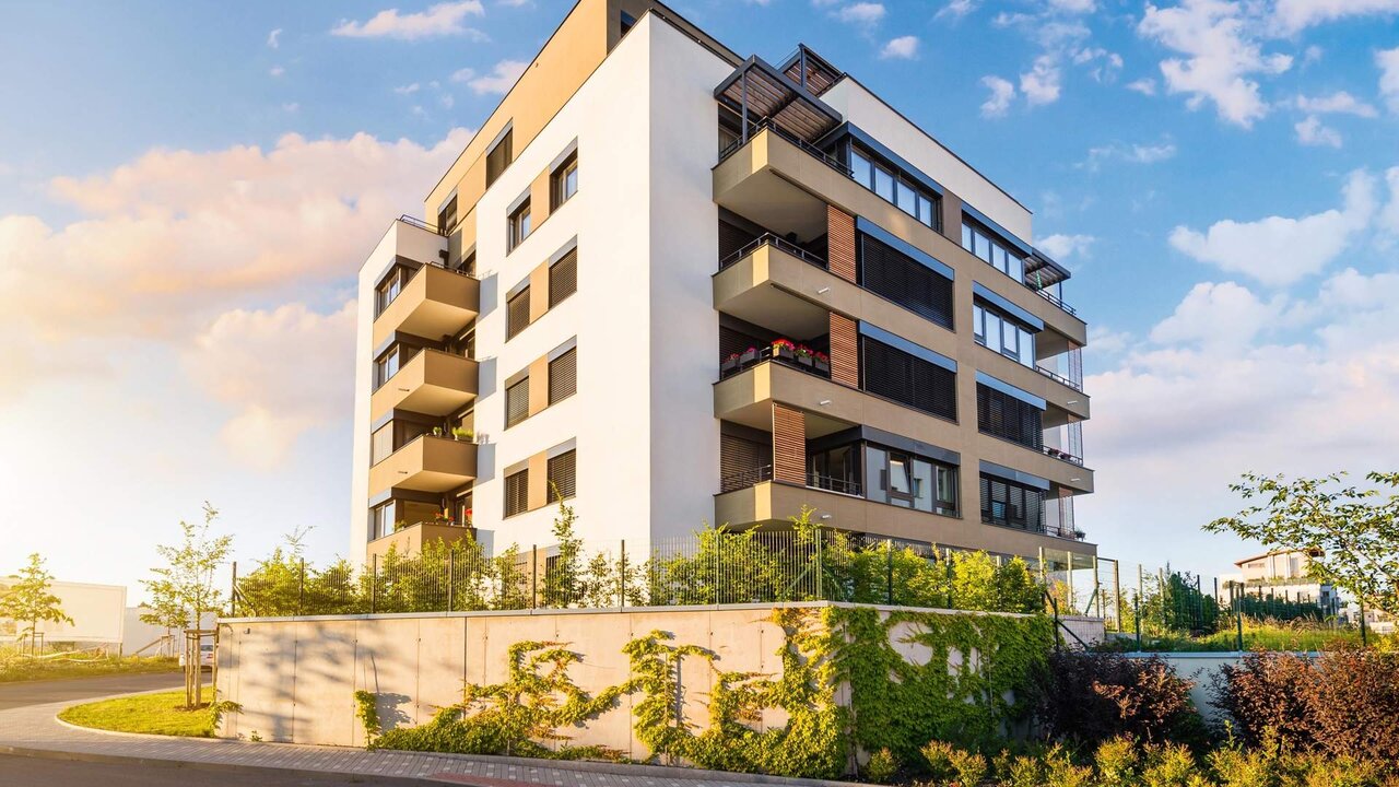New modern block of flats in green area with blue sky