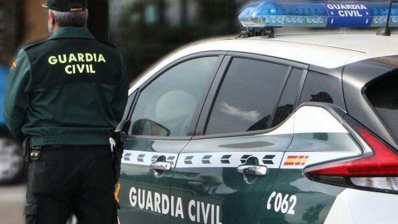 Un agente de la Guardia Civil junto a un veh&iacute;culo del cuerpo.