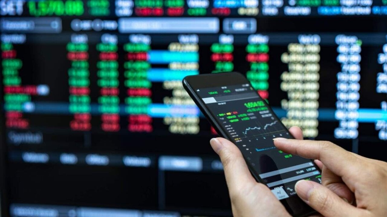 Businessman checking stock market data. He using a mobile phone. Analysis economy data on forex earn graph.