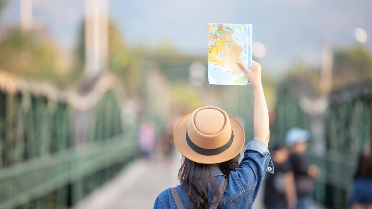 Female tourists on hand have a happy travel map.