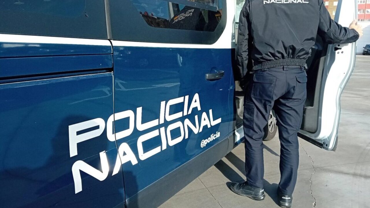Archivo - Un agente y un coche de la Polic&iacute;a Nacional.