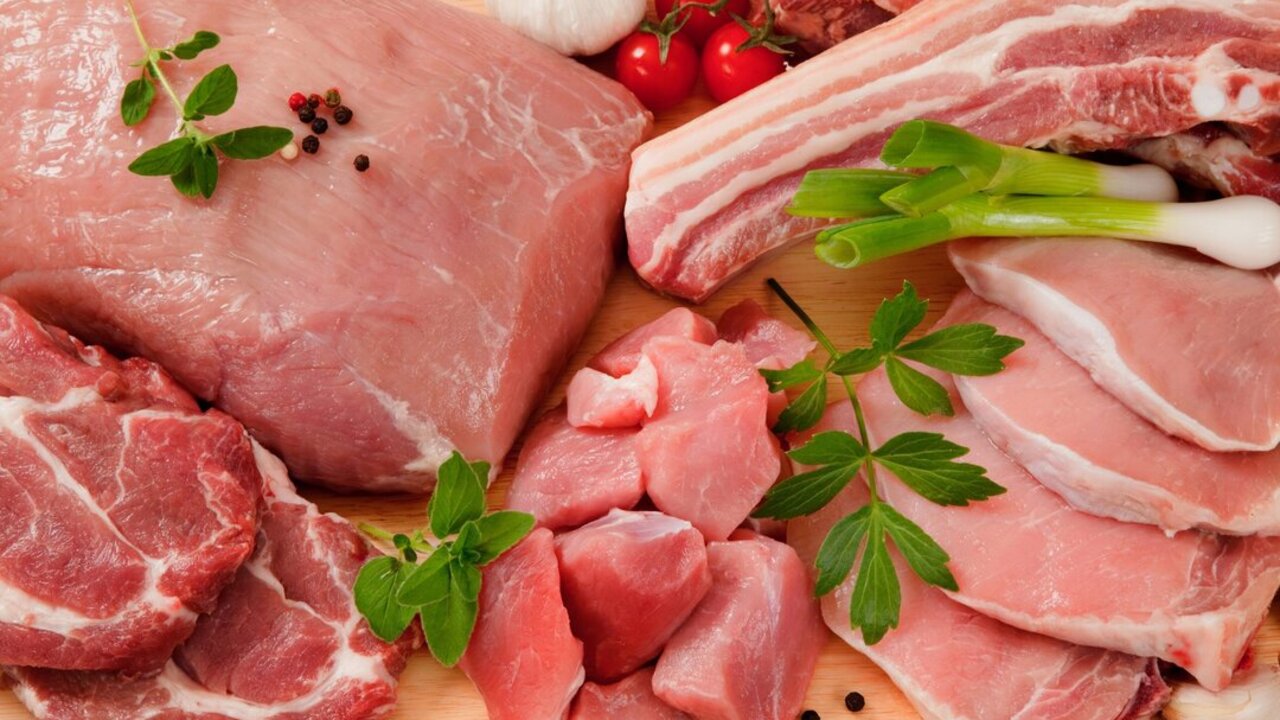 Detail - different type of meat (pork steak, tenderloin, belly, neck, shoulder) decorated on a chopping board with garnish