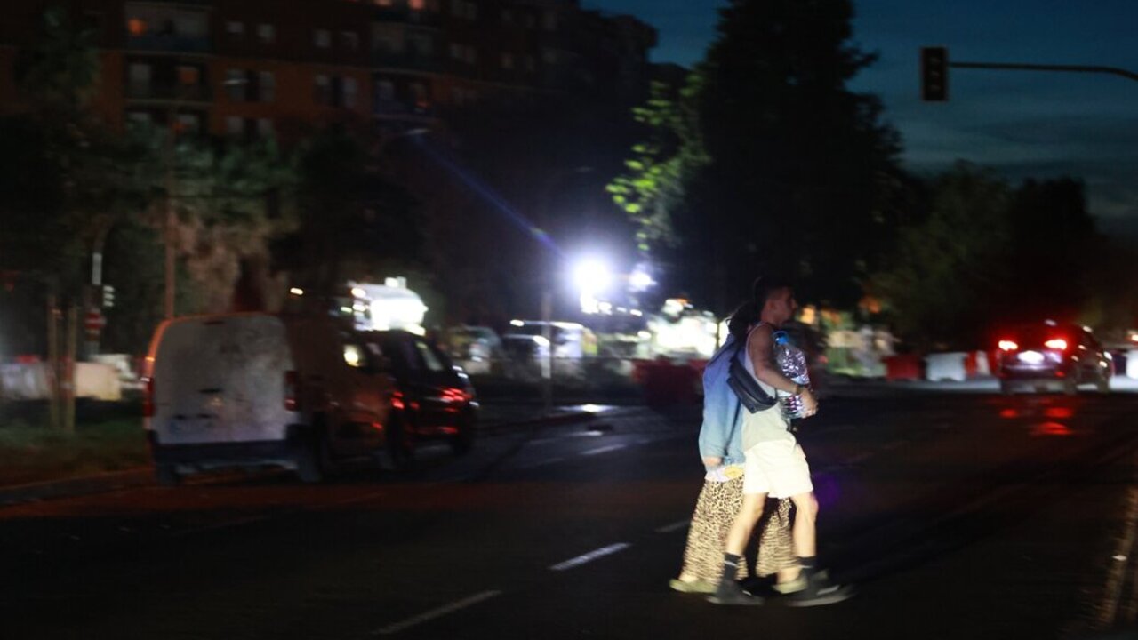 Unas personas cruzan una calle a oscuras durante el apag&oacute;n el&eacute;ctrico generalizado en el barrio de Sevilla este. A 28 de abril de 2025, en Sevilla. (Foto: Roc&iacute;o Ruz / Europa Press)
