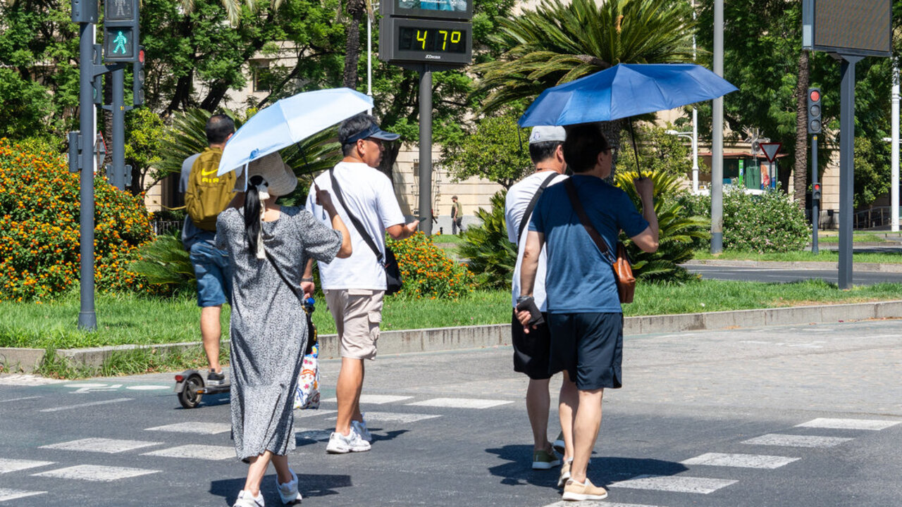 Im&aacute;genes de personas al lado de un term&oacute;metro en las calles de Sevilla a 47 grados de temperatura. (Foto: Francisco J. Olmo / Europa Press)