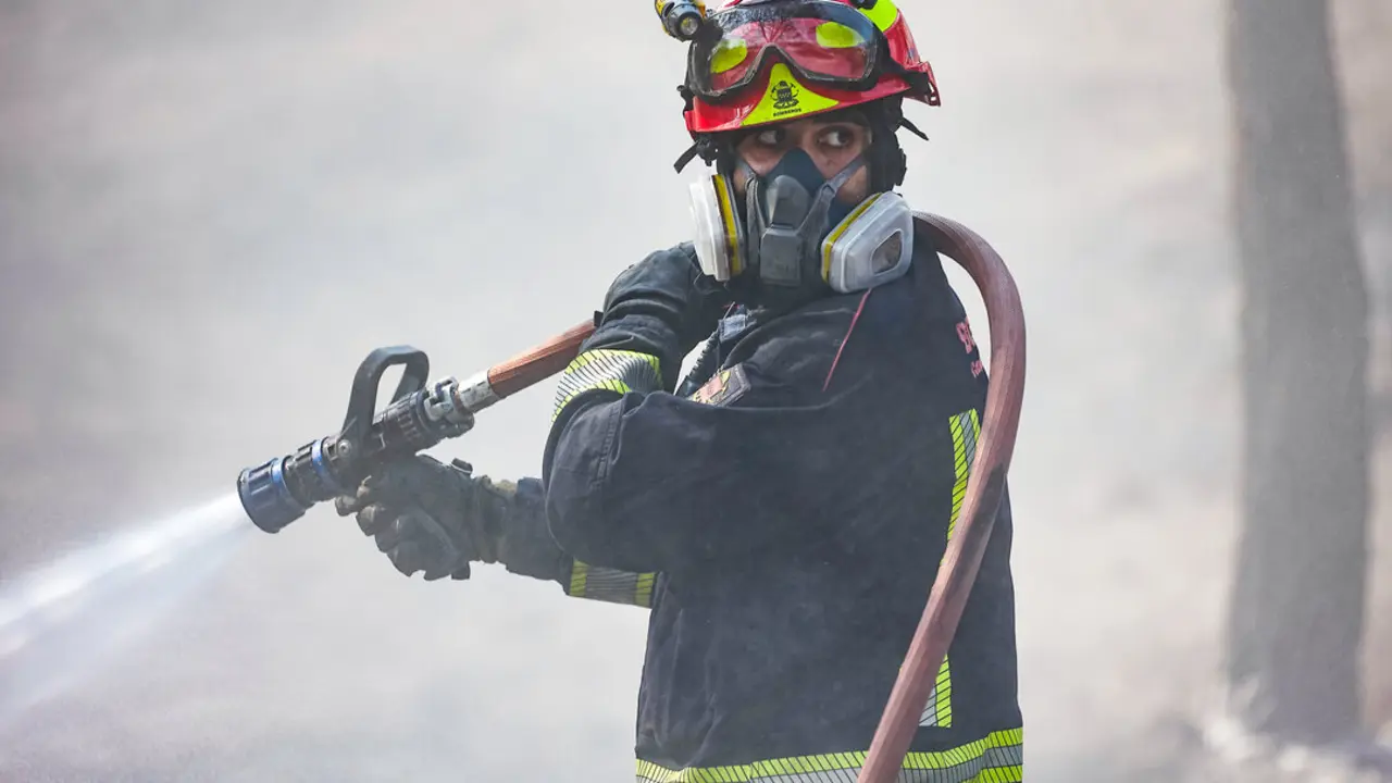 Un bombero de la Comunidad de Madrid sujeta una manguera para extinguir un incendio, a 19 de agosto de 2025, en Colmenar Viejo. (Foto: Jesús Hellín / Europa Press)