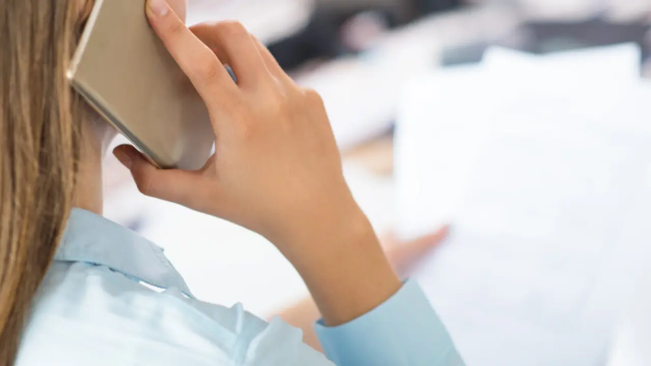 Una mujer de espaldas hablando por teléfono