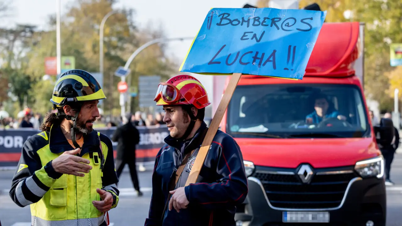 Dos bomberos con una pancarta durante la manifestación de la Coordinadora Unitaria de Bomberos Profesionales (CUBP), a 30 de noviembre de 2024, en Madrid. (Foto: Ricardo Rubio / Europa Press)