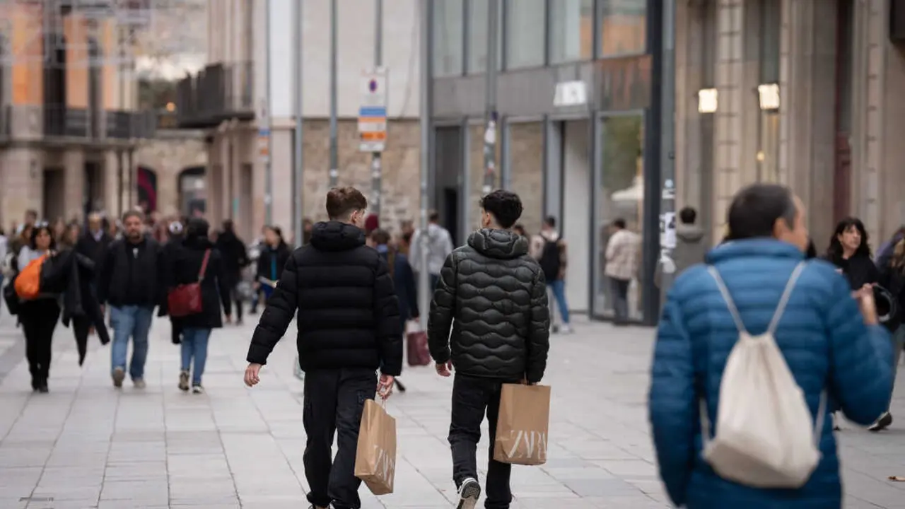 Jóvenes sujetan bolsas con compras durante la campaña de Navidad en Barcelona. (Foto: David Zorrakino / Europa Press)