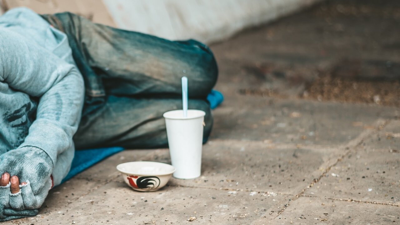 Mendigos tendidos al costado de la calle con ropa sucia (Foto: jcomp / Freepik).