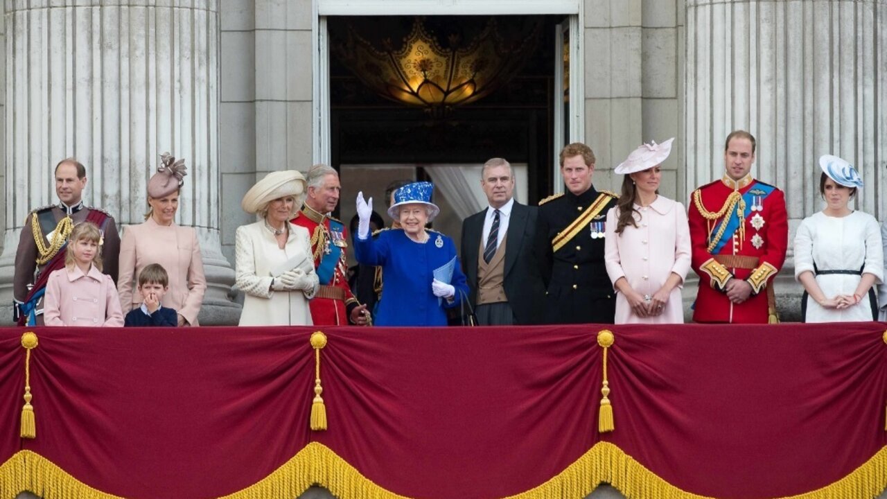 La reina Isabel saluda en el Palacio de Buckingham rodeada por su familia.