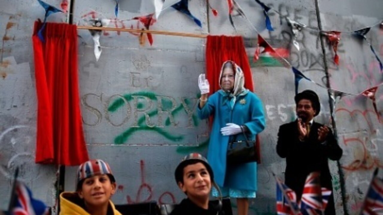 Montaje del grafitero Banksy en el muro que separa Israel de Palestina.