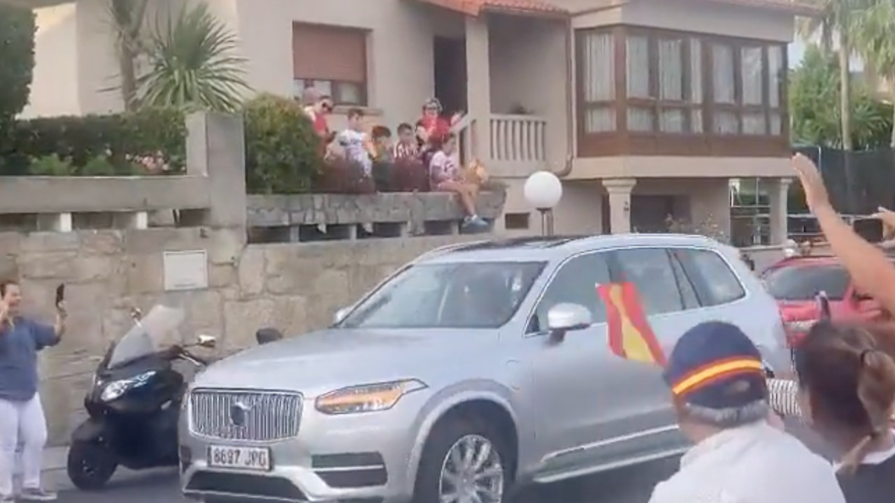 Pedro Campos llega conduciendo su coche, mientras varios vigueses gritan "viva el rey".