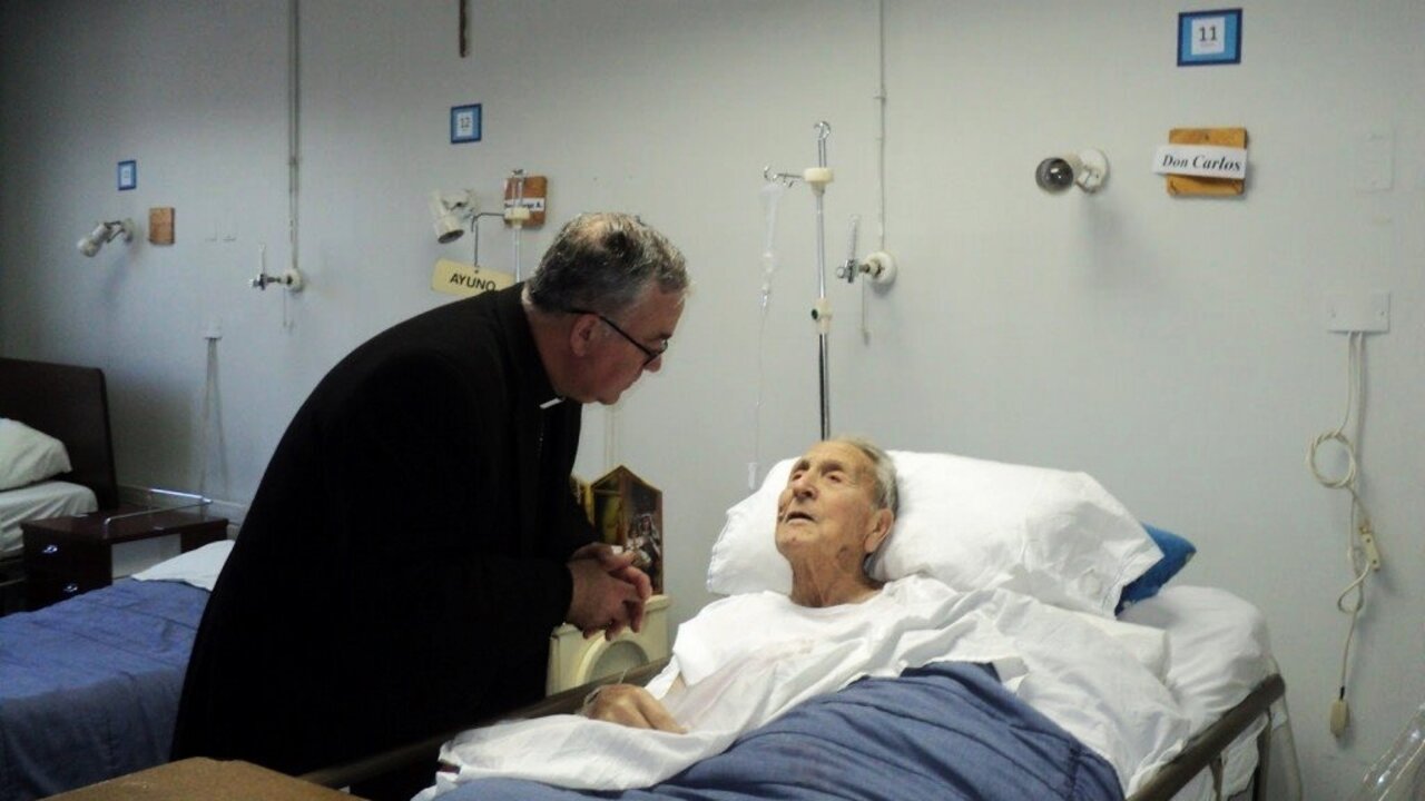 El capell&aacute;n de un hospital de Zamora atiende a una enferma.