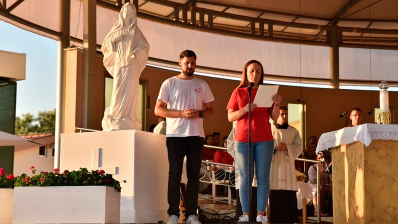 Dos jóvenes leen el mensaje del Papa Francisco en Medjugorje. 