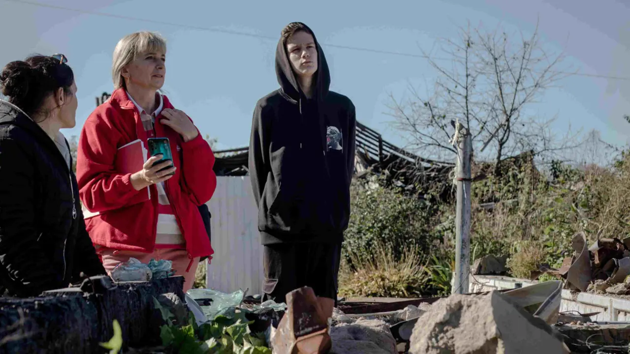 Una familia frente a su casa, que fue alcanzada por un misil ruso en marzo de 2022 en el pueblo de Muraivka (Chernihiv) ©Caritas Spes.