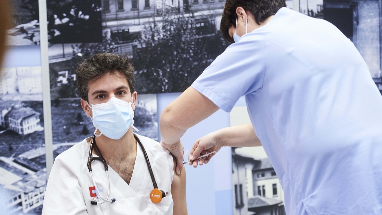 Una trabajadora sanitaria inyecta la segunda dosis de la vacuna de Pfizer-BioNTech contra la Covid-19 a un sanitario del Hospital Universitario Marqu&eacute;s de Valdecilla, en Santander, Cantabria.