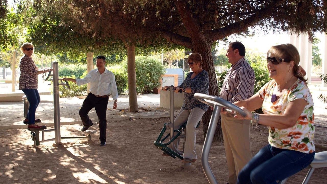 Personas mayores en una zona de juegos biosaludables en un parque.