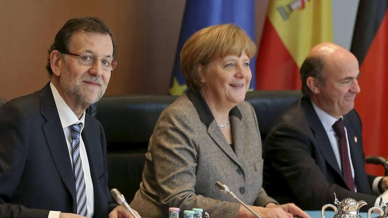Rajoy, Merkel, y De Guindos.
