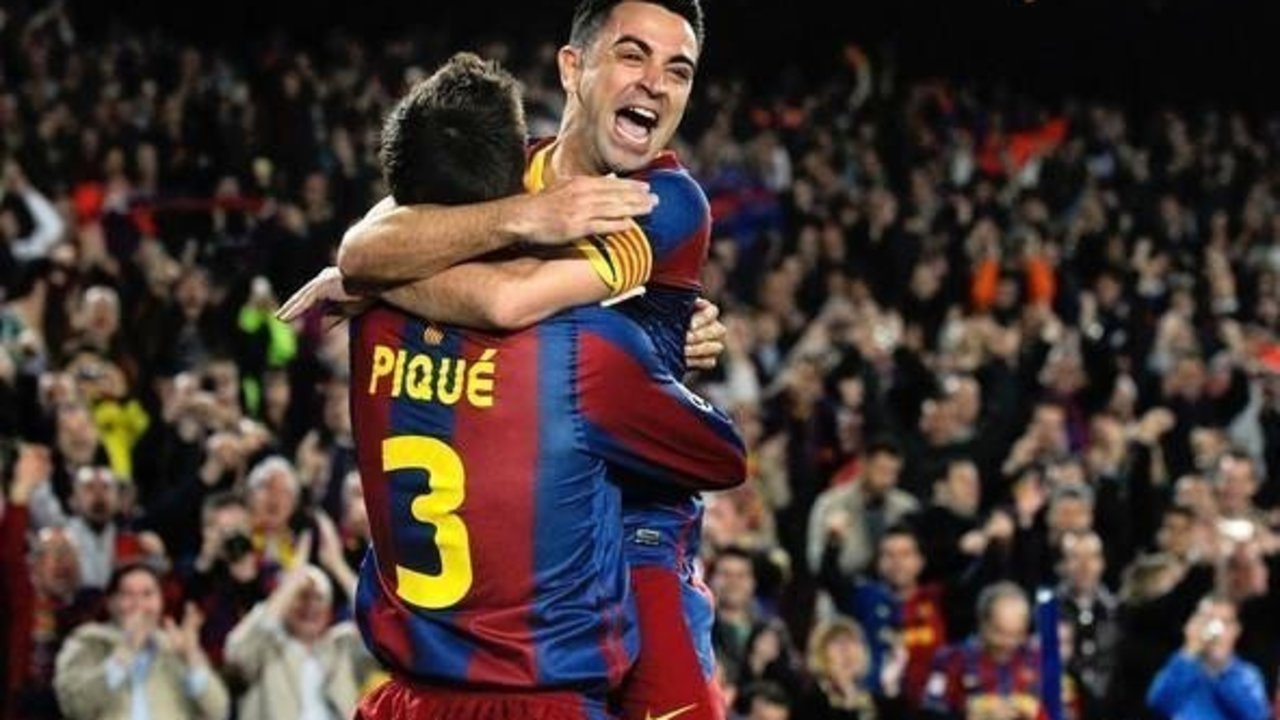 Xavi Hernández y Gerard Piqué celebran un gol del FC Barcelona.