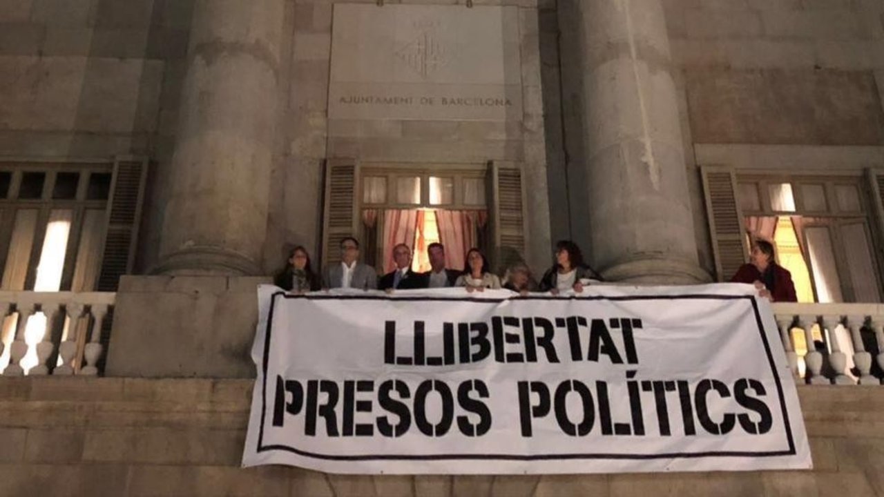 Concejales de PDeCAT y ERC cuelgan una pancarta en el Ayuntamiento de Barcelona.