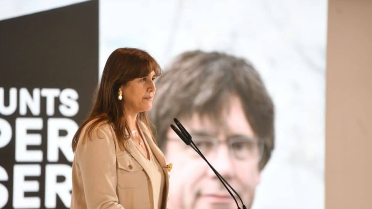 Laura Borràs, ante una imagen de Carles Puigdemont en un mitin de Junts.