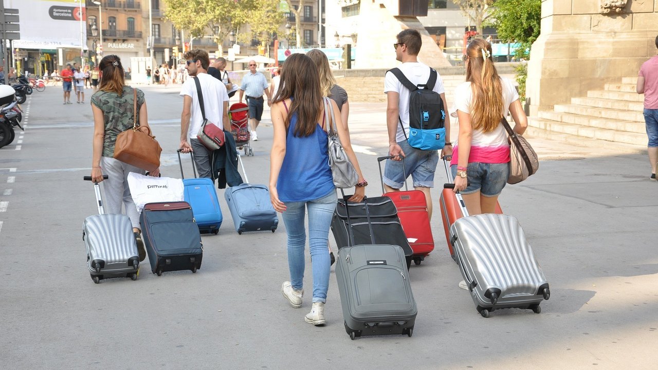 Varias personas con sus maletas.
