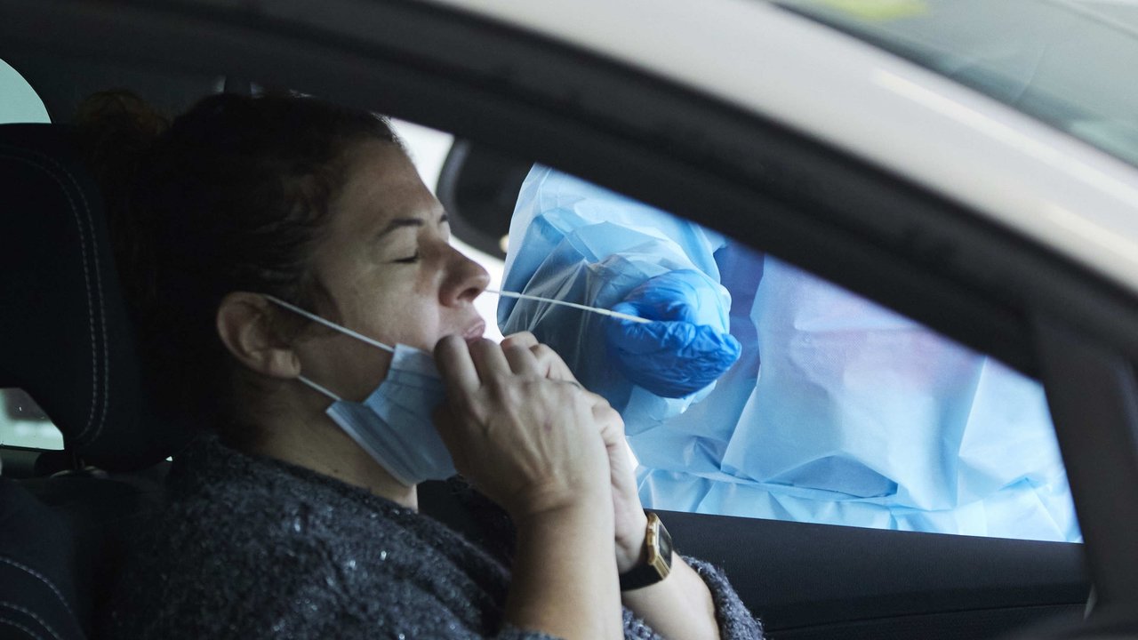 Una señora se realiza una prueba PCR en su coche durante la realización de PCR en el autocovid instalado en el Hospital Militar, a 28 de diciembre de 2021 en Sevilla (Andalucía, España)

