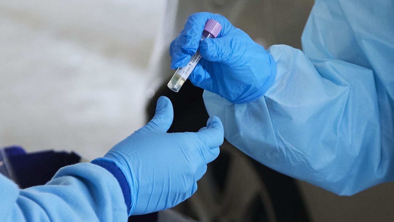 Una enfermera da una muestra de PCR para su análisis durante la realización de PCR en el autocovid instalado en el Hospital Militar, a 28 de diciembre de 2021 en Sevilla (Andalucía, España)

