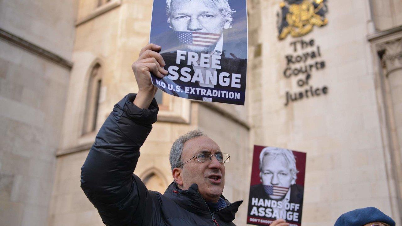 A protester holds a placard expressing his opinion at the Royal Courts of Justice..U.S wins appeal to extradite Wikileaks founder Julian Assange from the UK.