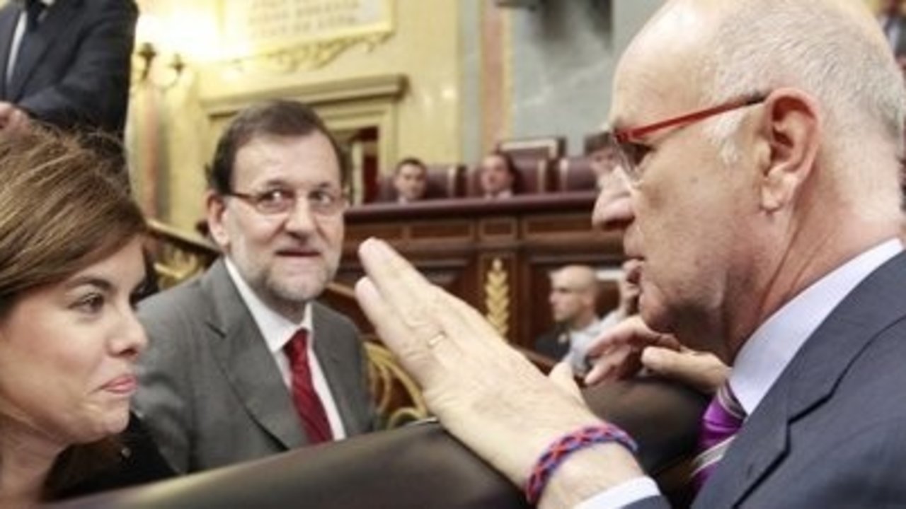 Sáenz de Santamaría y Duran Lleida conversan en el Congreso ante la atenta mirada de Rajoy.