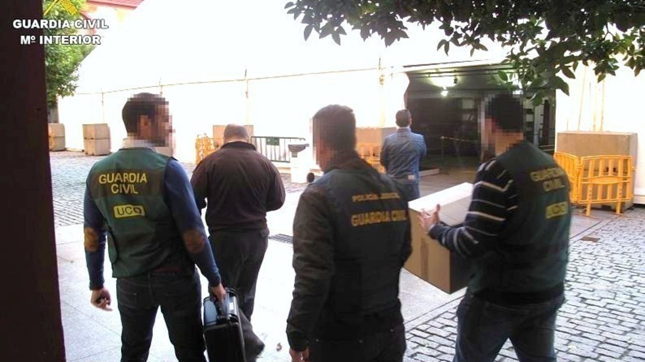 Agentes de la UCO de la Guardia Civil se llevan material intervenido en la Operación Enredadera.