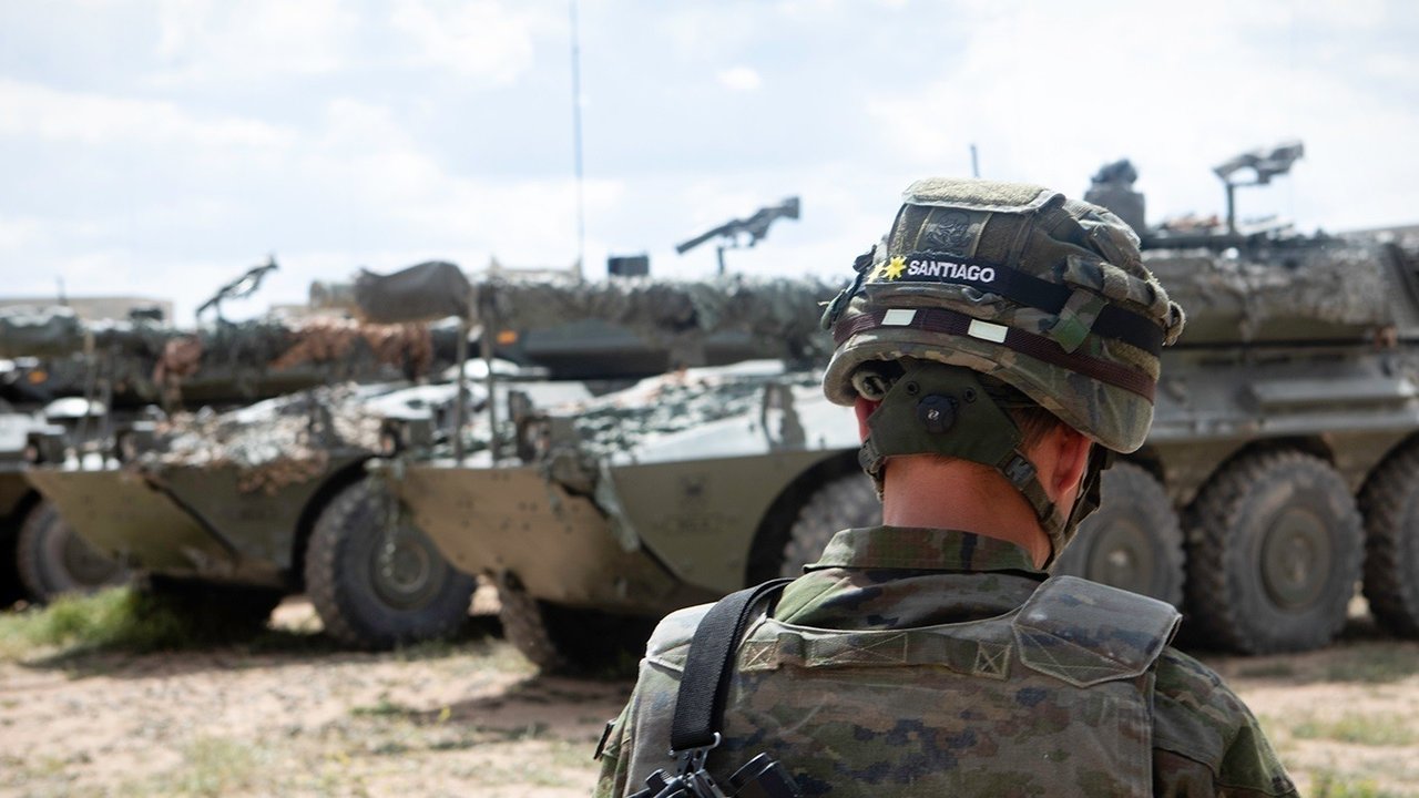Un militar ante varios carros blindados.