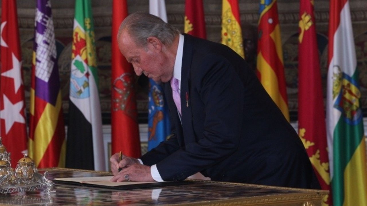 Juan Carlos I firma la ley orgánica por la que abdicó en Felipe VI, el 18 de junio de 2014.