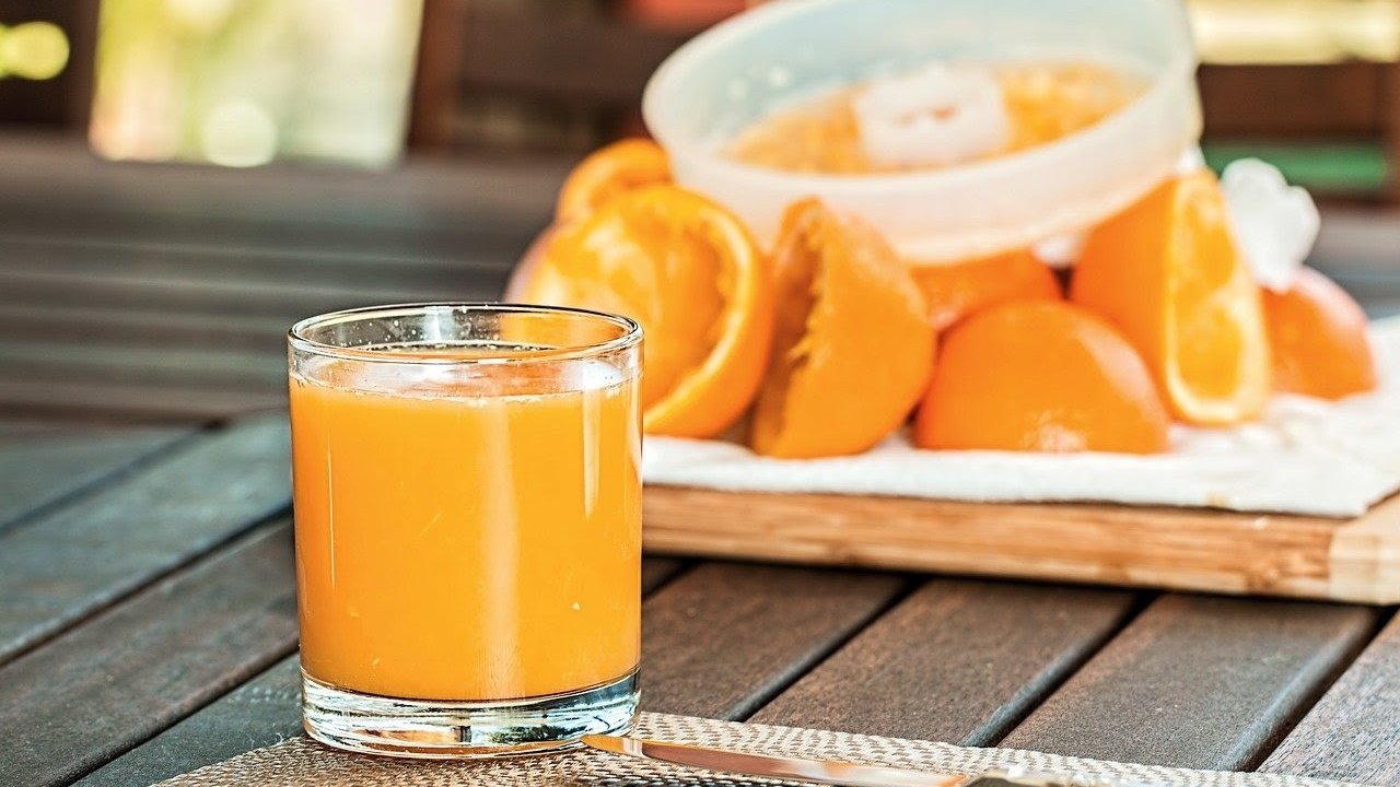 Un vaso lleno de zumo de naranja natural.